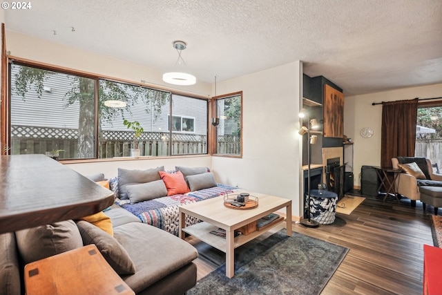 living room featuring a textured ceiling, a fireplace, and dark hardwood / wood-style flooring