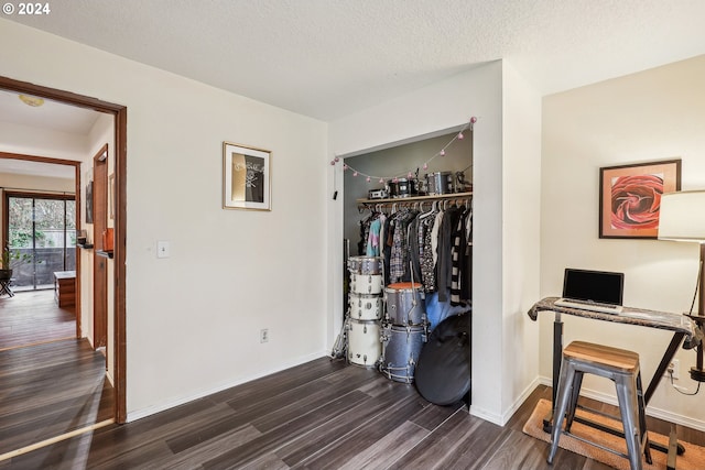 bedroom featuring a textured ceiling, dark hardwood / wood-style floors, and a closet