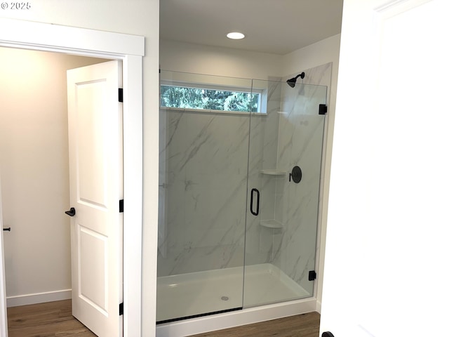 bathroom with hardwood / wood-style floors and an enclosed shower