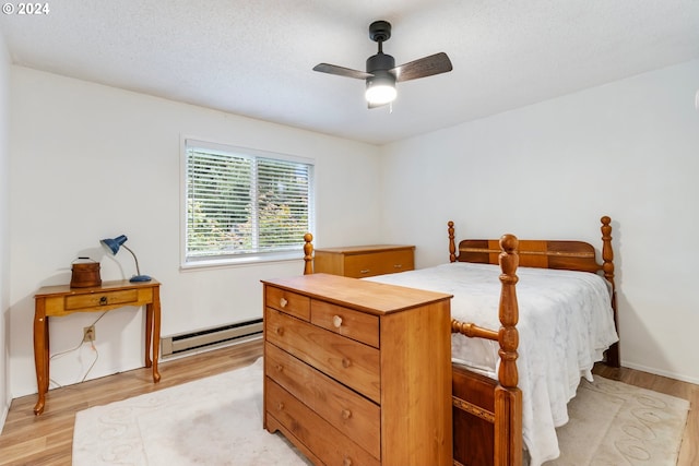 bedroom with a textured ceiling, ceiling fan, a baseboard radiator, and light wood-type flooring