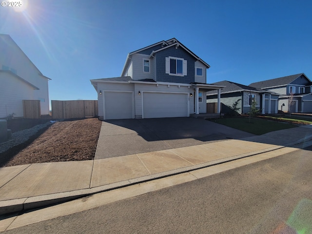 traditional-style home featuring driveway, a garage, fence, and a residential view