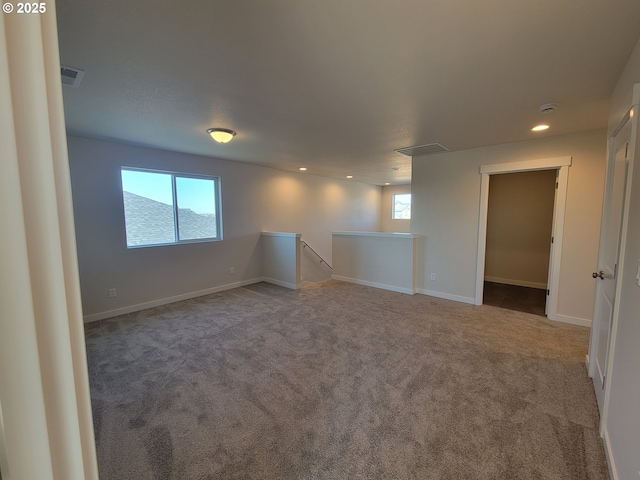 empty room featuring carpet floors, visible vents, baseboards, and recessed lighting