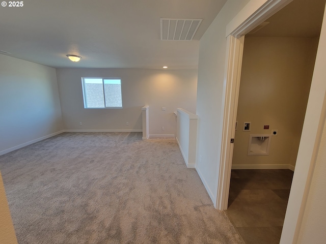 unfurnished room with carpet floors, visible vents, and baseboards