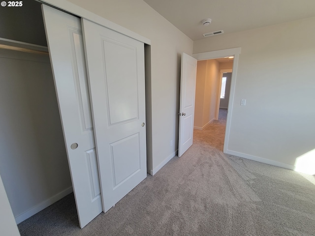 unfurnished bedroom featuring a closet, baseboards, visible vents, and carpet flooring