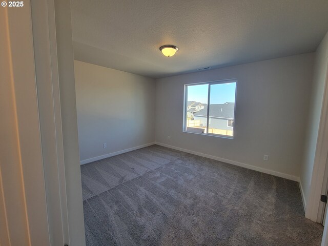 spare room featuring baseboards, a textured ceiling, visible vents, and carpet flooring