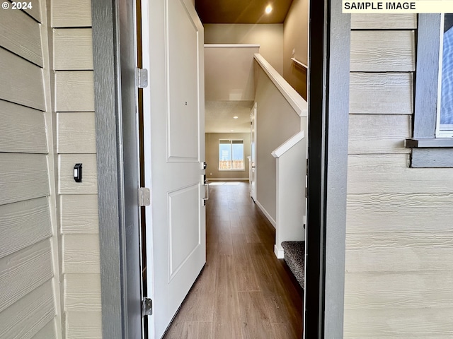 corridor with stairway, baseboards, and wood finished floors