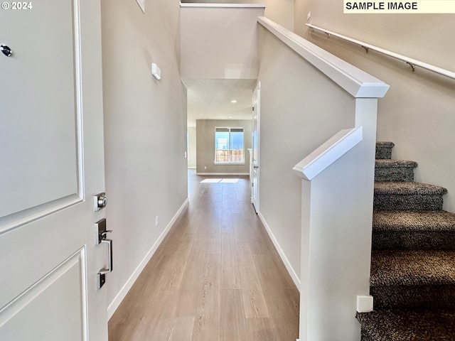 foyer featuring stairway, baseboards, and wood finished floors