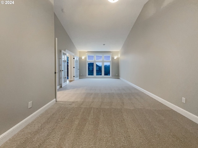 interior space with light colored carpet and vaulted ceiling