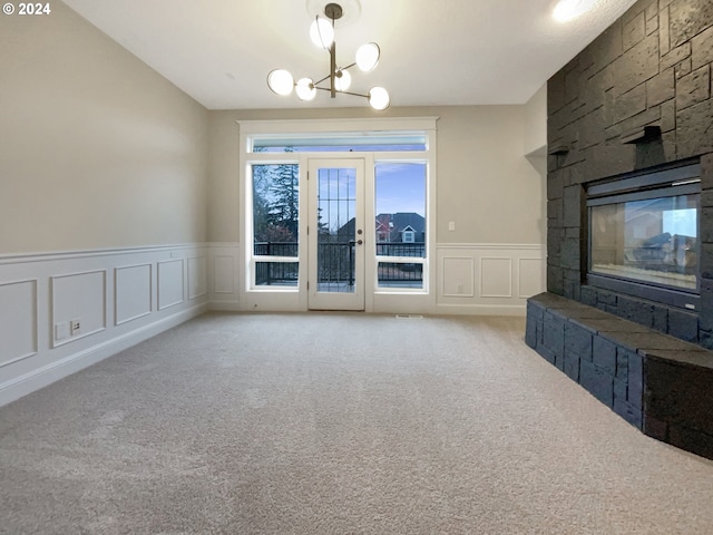 11574 SE Ross Rd, Happy Valley, OR 97086 - unfurnished living room featuring a decorative wall, carpet floors, wainscoting, a fireplace, and a chandelier