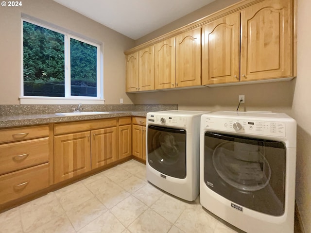 washroom with cabinets, sink, and washing machine and clothes dryer