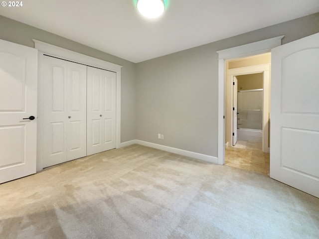 unfurnished bedroom with light colored carpet and a closet