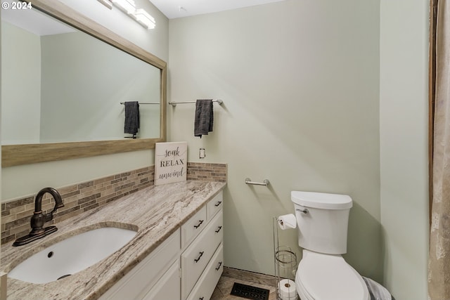 bathroom with backsplash, toilet, and vanity