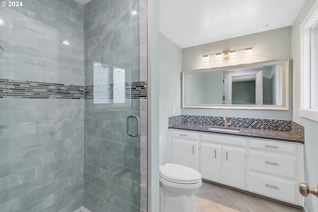 bathroom featuring vanity, toilet, an enclosed shower, and tile patterned flooring