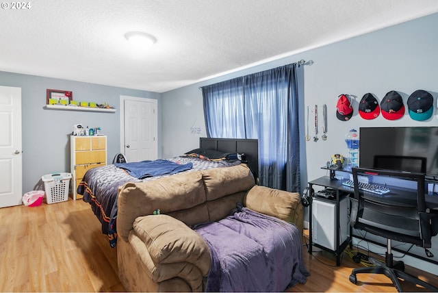 bedroom featuring hardwood / wood-style floors and a textured ceiling