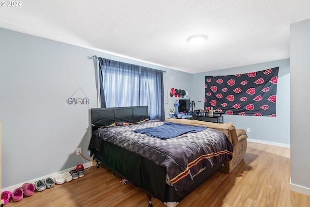 bedroom with a textured ceiling and hardwood / wood-style floors