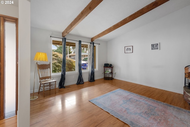 interior space with light hardwood / wood-style floors and lofted ceiling with beams