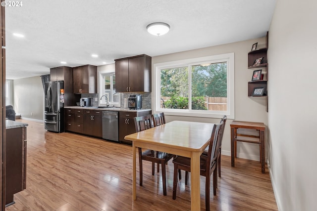 kitchen featuring light wood-type flooring, stainless steel appliances, sink, and dark brown cabinetry