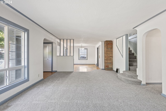 unfurnished living room with a textured ceiling and carpet