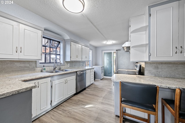 kitchen with white cabinets, sink, a textured ceiling, backsplash, and appliances with stainless steel finishes