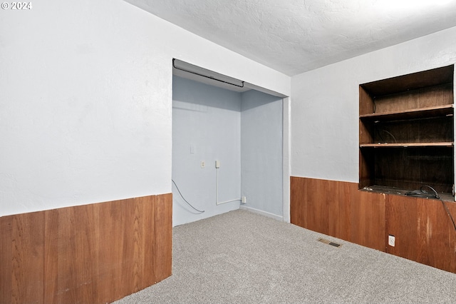 unfurnished bedroom featuring a textured ceiling and light colored carpet