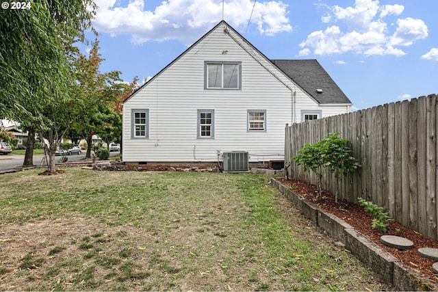 rear view of house featuring a yard and cooling unit