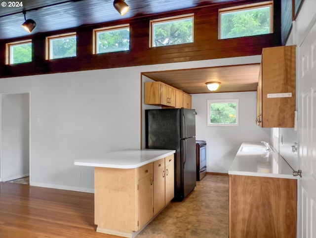 kitchen with sink, black fridge, wood ceiling, stainless steel electric range oven, and kitchen peninsula