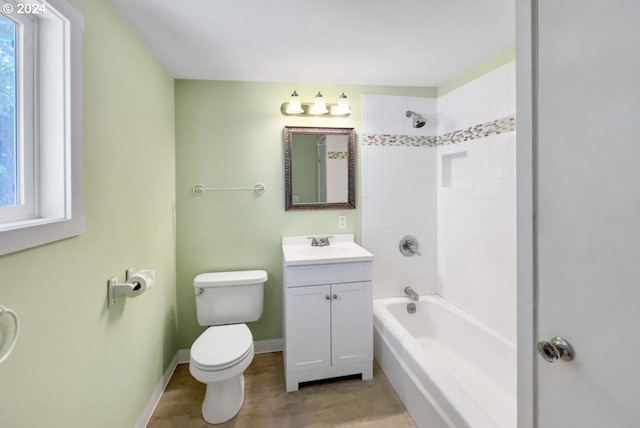 full bathroom with hardwood / wood-style flooring, tiled shower / bath, vanity, and toilet