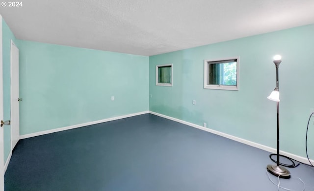 unfurnished room with concrete floors and a textured ceiling