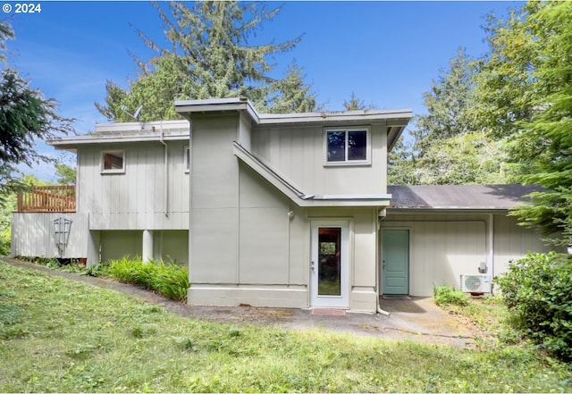 rear view of property with a yard and ac unit