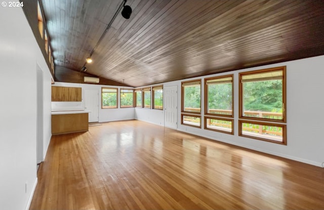 unfurnished living room featuring vaulted ceiling, a wall mounted AC, wood ceiling, and light hardwood / wood-style flooring