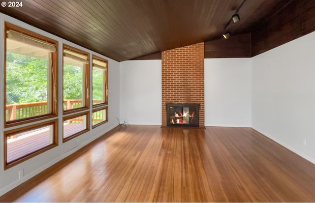 unfurnished living room featuring wood ceiling, light hardwood / wood-style flooring, a fireplace, track lighting, and vaulted ceiling