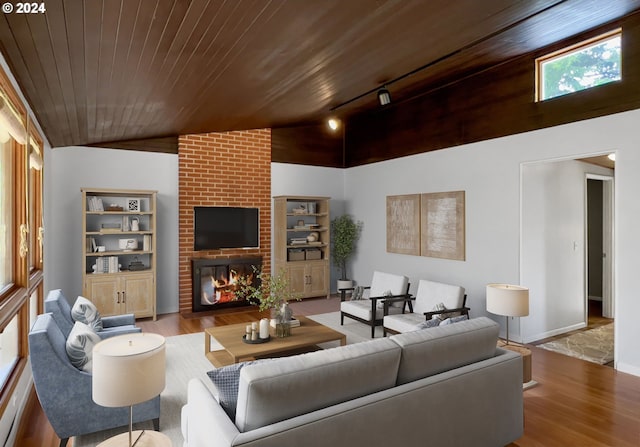 living room with rail lighting, a brick fireplace, vaulted ceiling, wooden ceiling, and light wood-type flooring