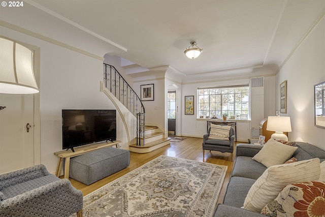 living room with crown molding and light hardwood / wood-style floors