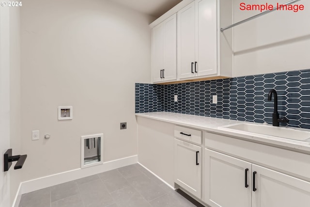 clothes washing area with cabinets, light tile patterned floors, sink, hookup for a gas dryer, and washer hookup