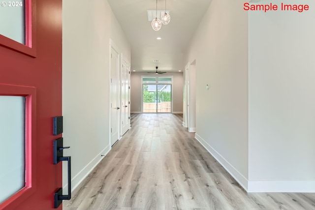 corridor with light wood finished floors, baseboards, and recessed lighting