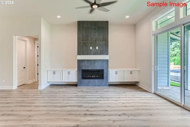 unfurnished living room featuring a healthy amount of sunlight, ceiling fan, and light wood-type flooring