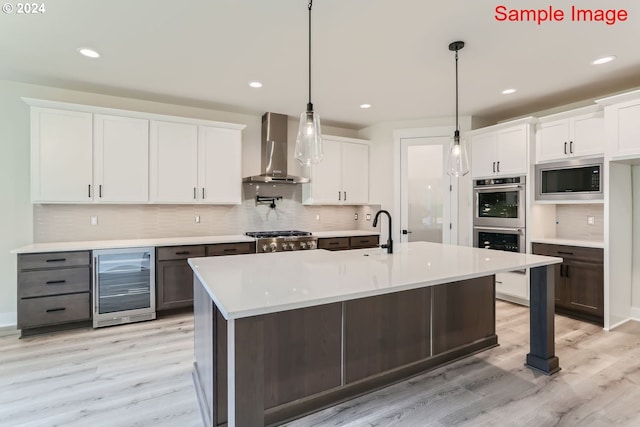 kitchen with wine cooler, wall chimney range hood, and white cabinets