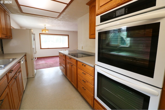 kitchen with a textured ceiling, sink, and white appliances