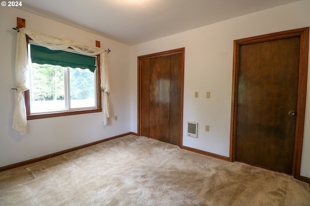 unfurnished bedroom with carpet floors and heating unit