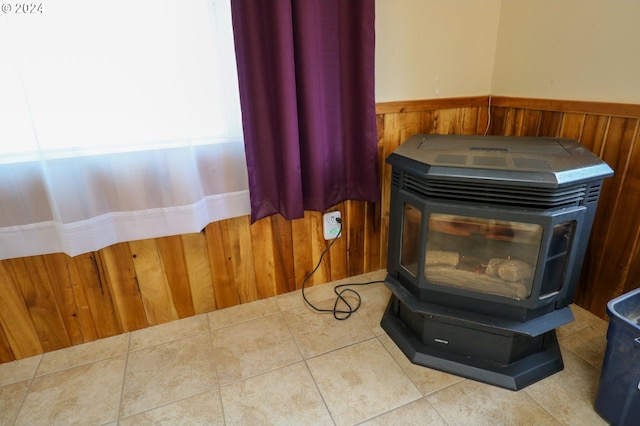 interior details with wood walls, tile patterned flooring, and a wood stove