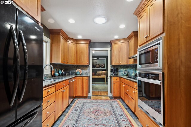 kitchen featuring decorative backsplash, stainless steel appliances, light hardwood / wood-style flooring, and sink