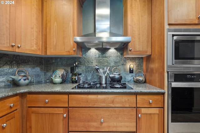 kitchen with stainless steel appliances, backsplash, and wall chimney range hood