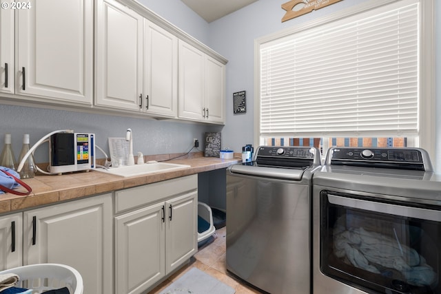 washroom with cabinets, light tile patterned floors, sink, and independent washer and dryer