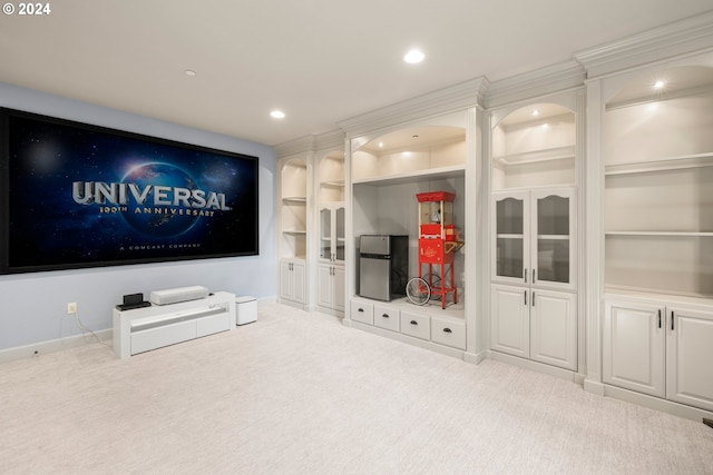 carpeted home theater featuring crown molding and built in shelves