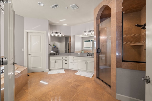 bathroom featuring tile patterned floors, vanity, and shower with separate bathtub