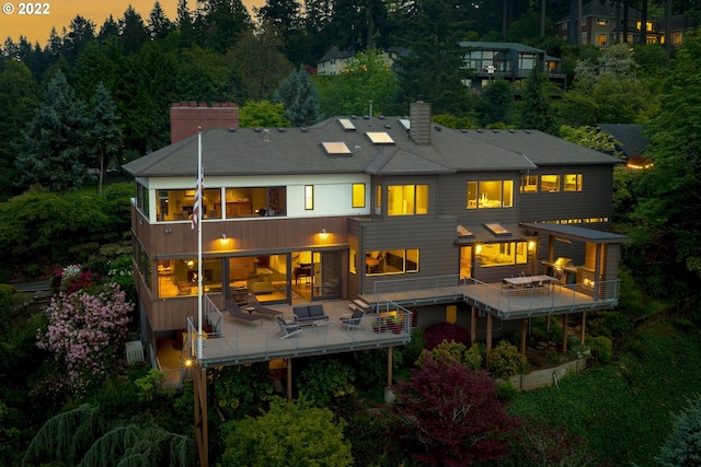 back house at dusk with a balcony