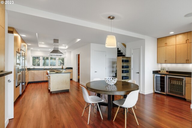 dining space with wood-type flooring, sink, and wine cooler