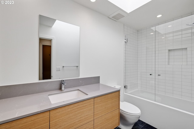 full bathroom with tile patterned flooring, toilet, tiled shower / bath combo, and vanity