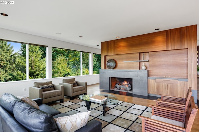 living room with a healthy amount of sunlight, light hardwood / wood-style flooring, and a high end fireplace