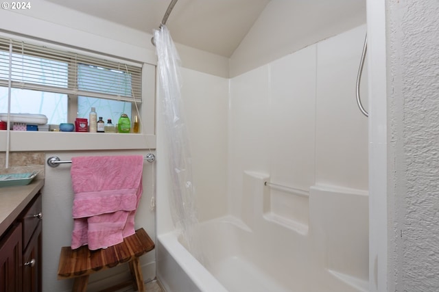 bathroom with lofted ceiling, shower / tub combo, and vanity